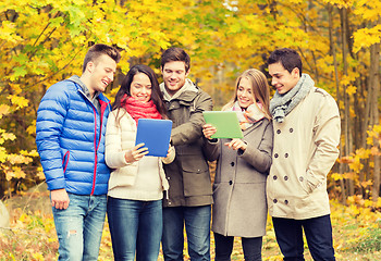 Image showing group of smiling friends with tablets in park