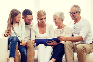 Image showing happy family with book or photo album at home