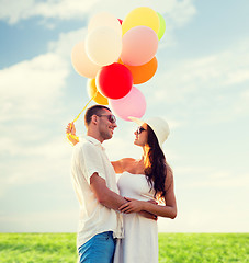 Image showing smiling couple with air balloons outdoors