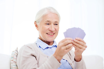 Image showing happy senior woman playing cards at home