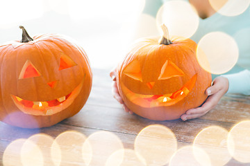 Image showing close up of woman with pumpkins at home