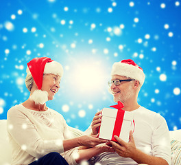 Image showing happy senior couple with gift box at home