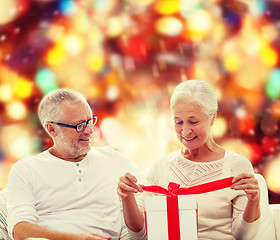 Image showing happy senior couple with gift box at home