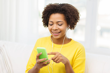 Image showing happy african woman with smartphone and earphones