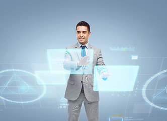 Image showing businessman in suit working with virtual screens