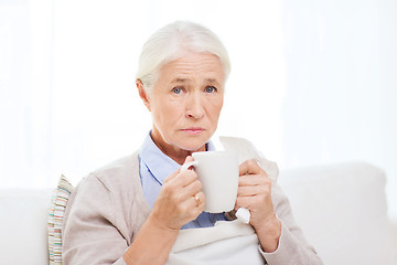 Image showing sick senior woman drinking hot tea at home