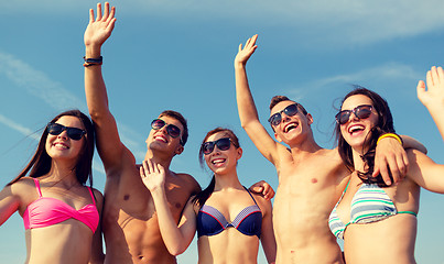 Image showing smiling friends in sunglasses on summer beach