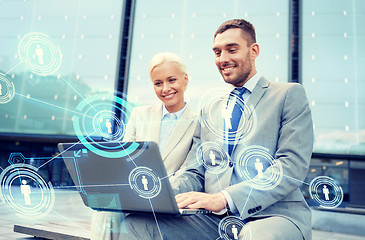 Image showing smiling businesspeople with laptop outdoors