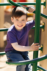 Image showing happy little boy climbing on children playground