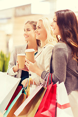 Image showing young women with shopping bags and coffee in mall