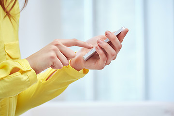 Image showing close up of female hands with smartphone at home