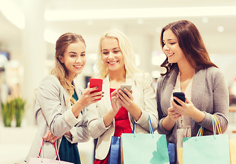 Image showing happy women with smartphones and shopping bags