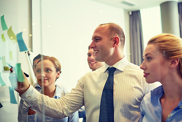 Image showing smiling business people with marker and stickers