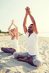 Image showing smiling couple making yoga exercises outdoors