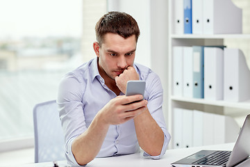 Image showing businessman with smartphone and laptop at office