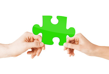 Image showing close up of couple hands with green puzzle