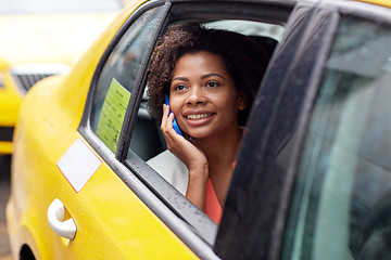 Image showing happy african woman calling on smartphone in taxi