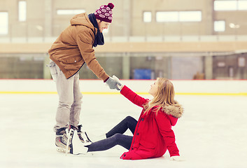 Image showing man helping women to rise up on skating rink