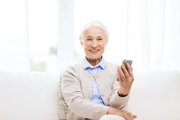 Image showing senior woman with smartphone at home