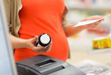 Image showing pregnant woman buying medication at pharmacy