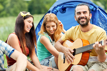 Image showing happy friends with drinks and guitar at camping