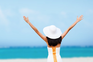 Image showing girl with hands up on the beach