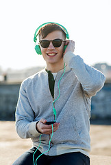 Image showing happy young man in headphones with smartphone