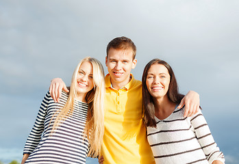 Image showing group of happy friends over sky background