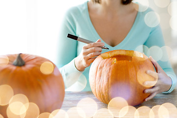 Image showing close up of woman with pumpkins at home