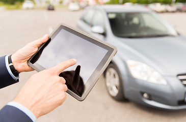 Image showing close up of young man with tablet pc and car