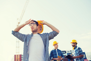 Image showing group of builders in hardhats outdoors