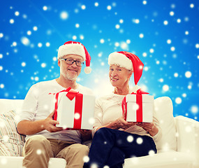 Image showing happy senior couple in santa hats with gift boxes