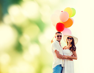 Image showing smiling couple with air balloons outdoors