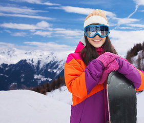 Image showing happy young woman with snowboard over mountains