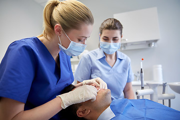 Image showing female dentist checking patient dental occlusion