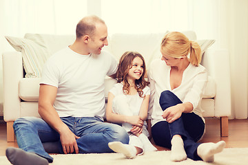 Image showing parents and little girl sitting on floor at home