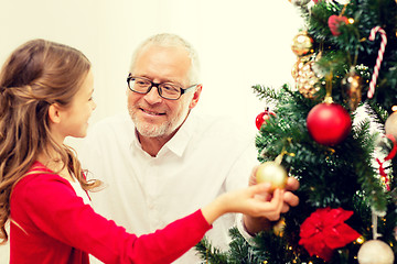 Image showing smiling family decorating christmas tree at home