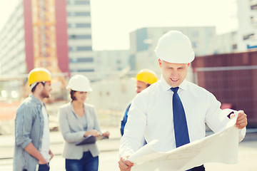 Image showing group of builders with tablet pc and blueprint