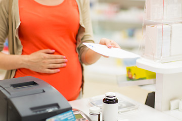 Image showing pregnant woman buying medication at pharmacy
