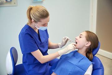 Image showing female dentist checking patient girl teeth