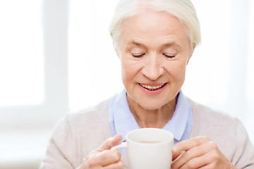 Image showing happy senior woman with cup of tea or coffee
