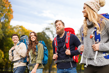 Image showing smiling friends with backpacks hiking over nature