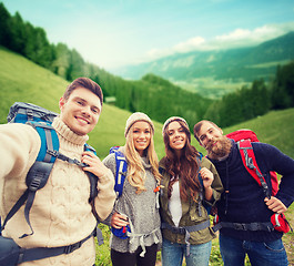 Image showing group of smiling friends with backpacks hiking