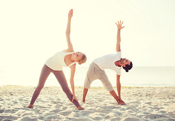 Image showing couple making yoga exercises outdoors