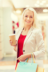 Image showing young woman with shopping bags and coffee in mall