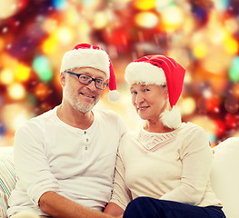 Image showing happy senior couple in santa helper hats