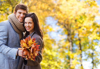 Image showing smiling couple hugging over autumn background