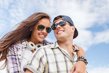 Image showing smiling teenagers in sunglasses having fun outside