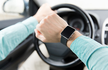 Image showing close up of man with wristwatch driving car