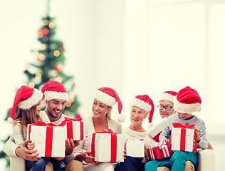 Image showing happy family in santa helper hats with gift boxes